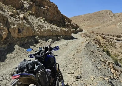 Adventure motorcycle on a rocky mountain trail in a remote high-altitude area of Morocco.