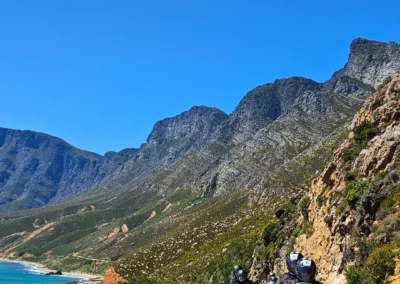 Adventure riders on a scenic coastal road near Cape Town, South Africa.