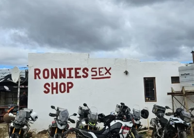 Adventure motorcycles parked outside Ronnies Sex Shop on Route 62 in South Africa.