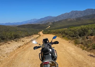 Adventure motorcycle on a winding dirt road through the mountains of South Africa.