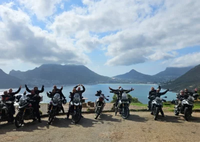 Group of adventure riders and motorcycles overlooking Hout Bay near Cape Town.