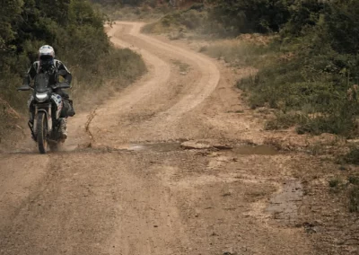 Adventure rider on a winding dirt road in Portugal.