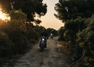 Two adventure riders on a trail at sunrise in Portugal.