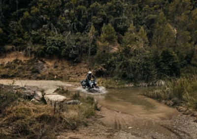 Adventure rider crossing a shallow stream in Portugal.