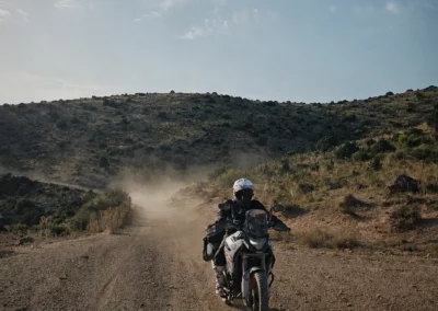 Adventure rider on a dusty off-road trail in Portugal.